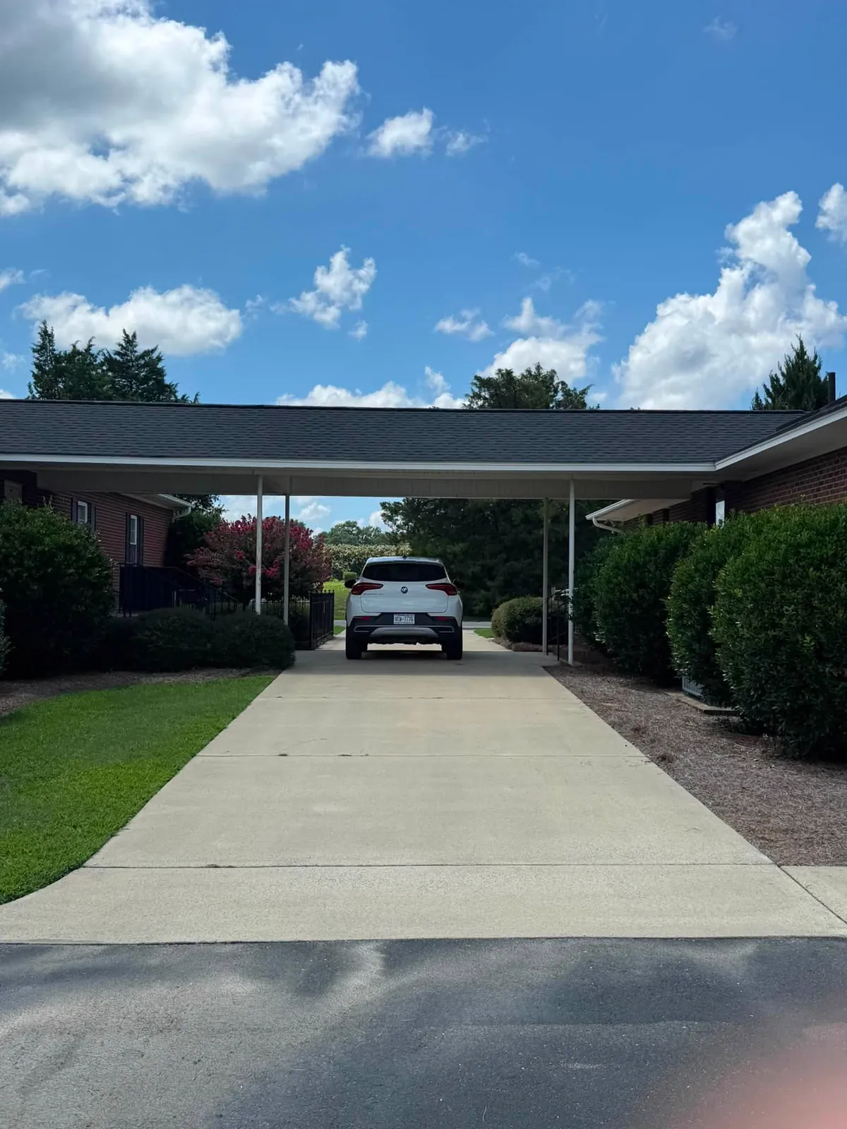 Clean concrete driveway running under a carport, a Reaves ProWash job
