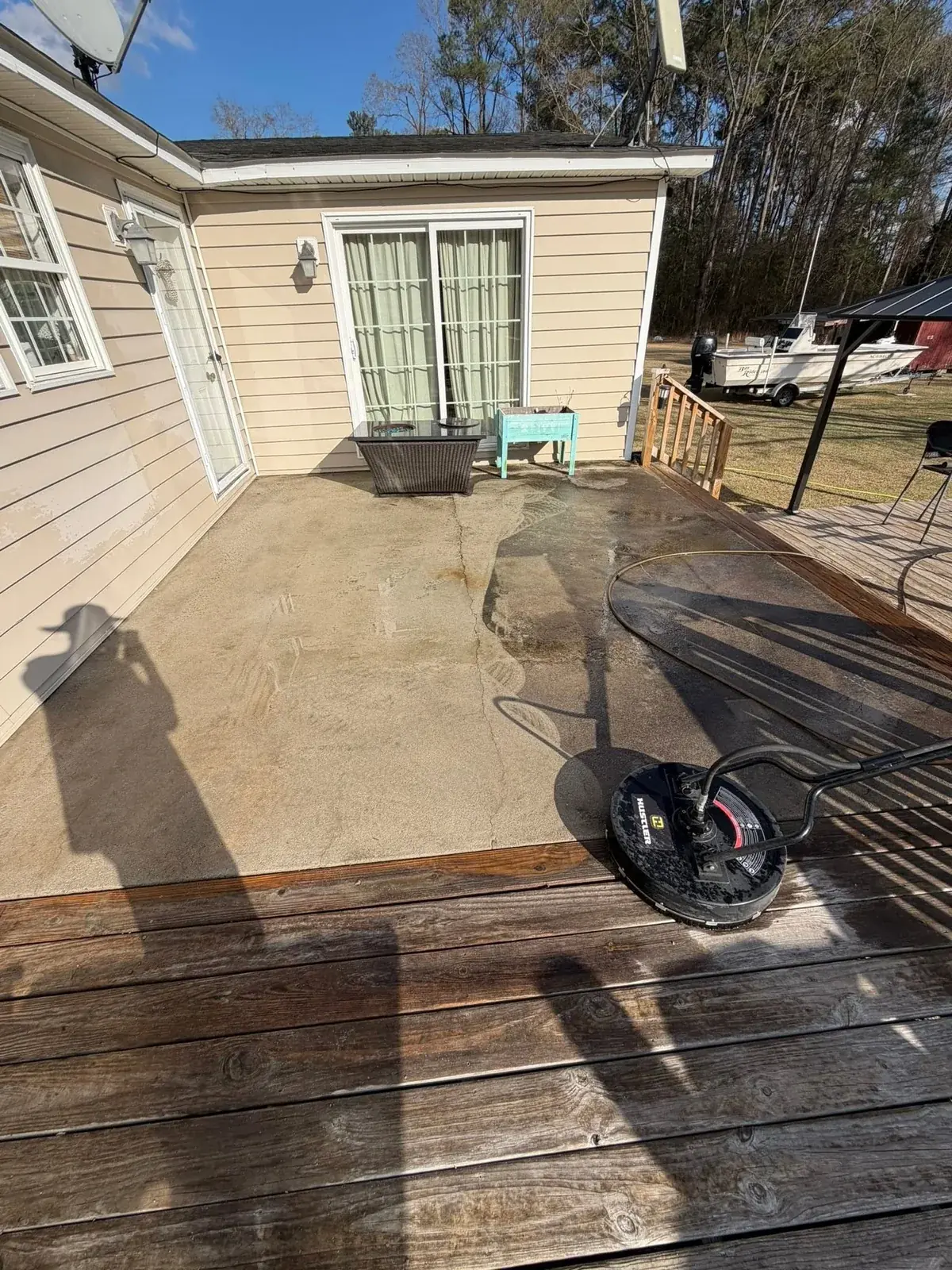 Surface-cleaning equipment beside a wooden deck and outdoor patio