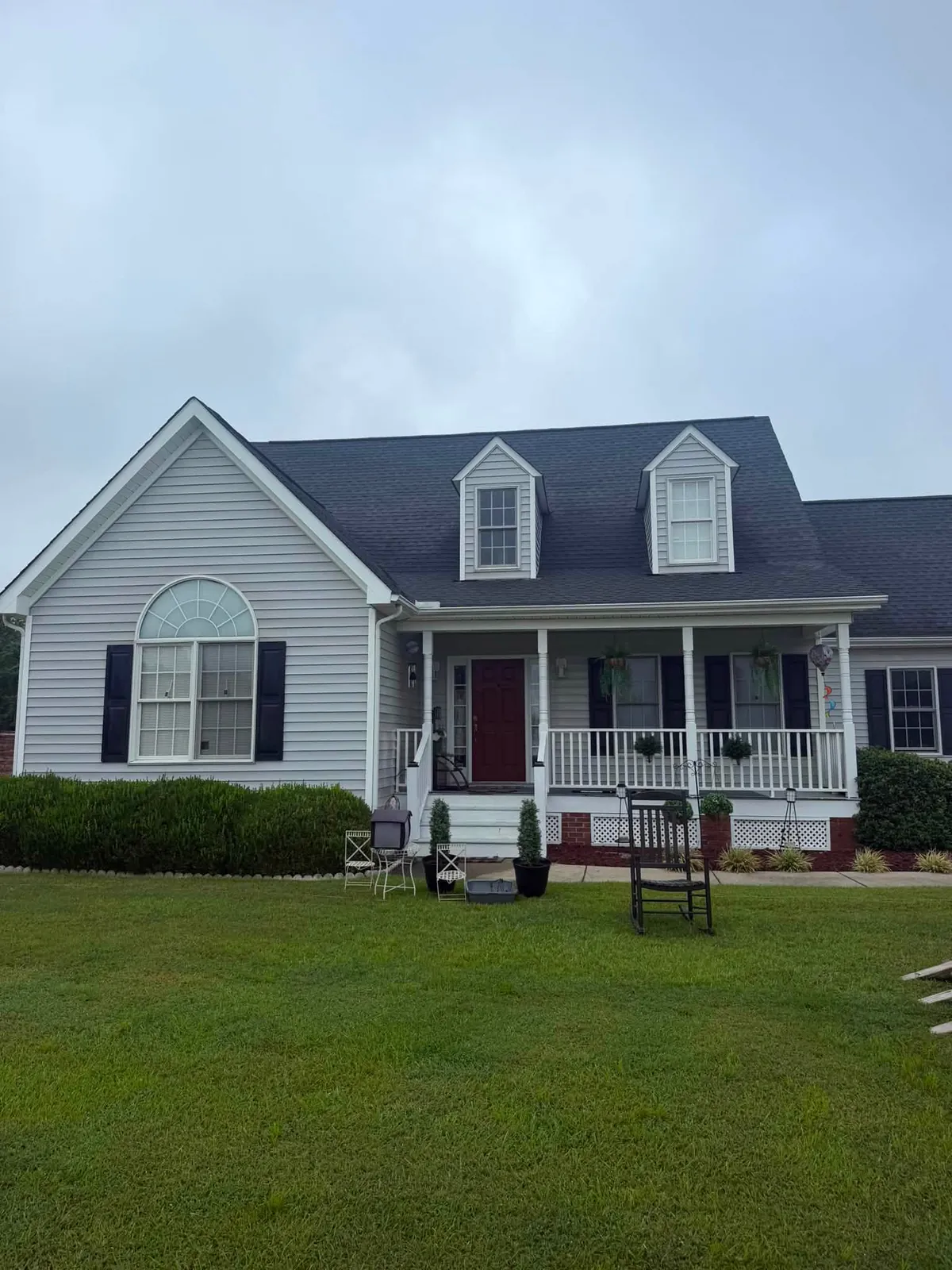 Gray home with black shutters and a white porch after a Reaves ProWash house wash